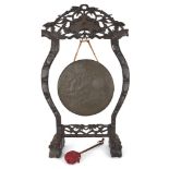 A Chinese gong and carved hongmu stand, early 20th century, the sides of the wood stand carved as
