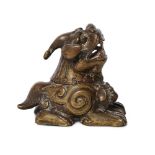 A Chinese bronze 'Luduan' scroll weight, 17th century, cast seated with a single horn and open jaws,