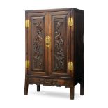 A Chinese huali wood cabinet, 19th century, the pair of doors finely carved with flowering lotus,