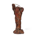 A Chinese carved bamboo figure of a fisherman, late 19th century, carved triumphantly presenting a