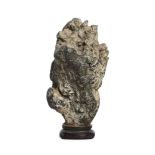 A Chinese small scholar's rock, gongshi, Qing dynasty, fixed atop a wood stand, 9.1cm high