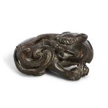 A Chinese gilt bronze 'recumbent lion' scroll weight, 17th century, cast with its head turned back