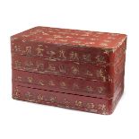 A Chinese lacquered wood three-tiered stacking box, 19th century, the cover and sides decorated with