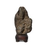 A Chinese small scholar's rock, gongshi, Qing dynasty, fixed atop a wood stand, 8.2cm high