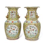 A pair of Chinese porcelain yellow-ground famille rose 'flowers' vases, 19th century, each painted