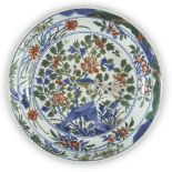 A Chinese porcelain wucai 'peacock' dish, late Ming dynasty/Transitional period, painted with a