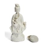 A Chinese Dehua porcelain figure of Guanyin, 18th century, modelled seated on a rocky outcrop with