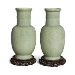 A pair of Chinese celadon-glazed carved 'lotus' vases, late Qing dynasty, the exteriors decorated