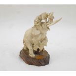 A Japanese ivory okimono, Meiji period, carved as two lions attacking an elephant, 13cm high, on