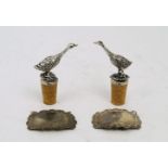Two silver decanter labels and a pair of goose bottle stoppers, the decanter labels for 'Gin' (