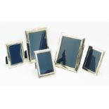 Five silver easel back photo frames, the two larger frames Sheffield, 1987 & 1990, D. R. & S., 17.