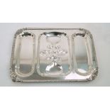 A silver plated meat dish raised on four lion paw feet, of rectangular form, designed with three