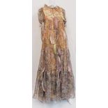 Gina Fratini, a boho evening gown, in a patterned chiffon depictiong female faces, birds and