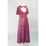 Makarian: a pink sequin A-line cocktail dress with front centre slit and bow twist detail, zip