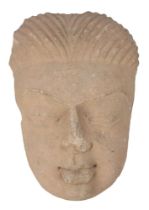 A Post-Gupta period sandstone face of Buddha, North India or Pakistan, 6th/7th century, with thin,