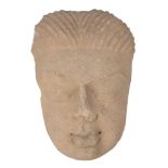 A Post-Gupta period sandstone face of Buddha, North India or Pakistan, 6th/7th century, with thin,