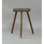 A Sheffield cutlery makers elm stool, the shaped plank top raised on three rough turned