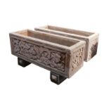 A Pair of rectangular earthenware planters, with carved floral side panels, raised on block bases,
