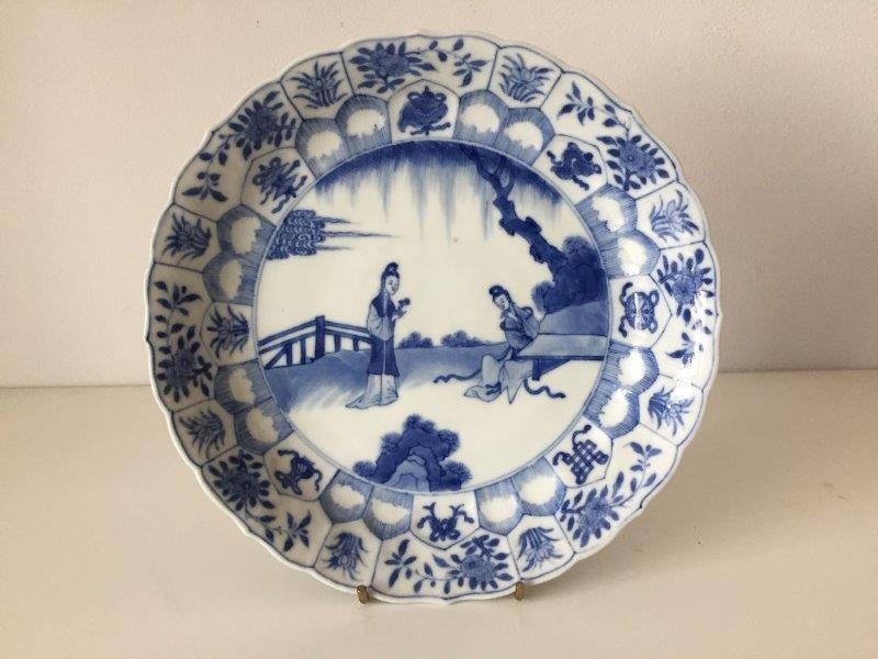 A Chinese porcelain blue and white moulded dish, Qing dynasty, painted with two ladies in a - Image 2 of 3