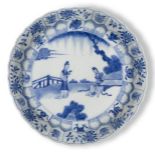 A Chinese porcelain blue and white moulded dish, Qing dynasty, painted with two ladies in a
