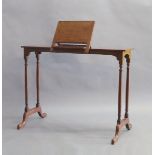 A walnut music stand, early 20th century, with hinged top, raised on cylindrical legs and splayed