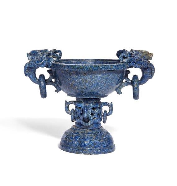 A Chinese carved lapis lazuli 'dragon' tazza, late 19th/ early 20th century, the bowl flanked by two