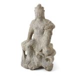 A large Chinese Tang-style carved stone figure of Guanyin, late Qing dynasty, depicted seated on a