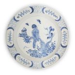 A Delft charger, 18th century, painted with a parrot perched on a branch, the border with