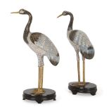 A pair of Chinese cloisonnÃ© enamel figures of storks, 20th century, on stained wood oval stands,