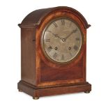 A German mahogany mantel clock, circa 1920, the case with arched moulded cornice, the brass dial