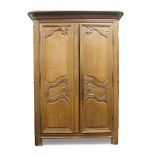 A French oak Armoire, 19th century, the cornice with rounded edges, above two carved panelled doors,