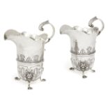 A pair of Portuguese silver cream jugs, Porto, .833 standard, the elongated bodies chased with shell