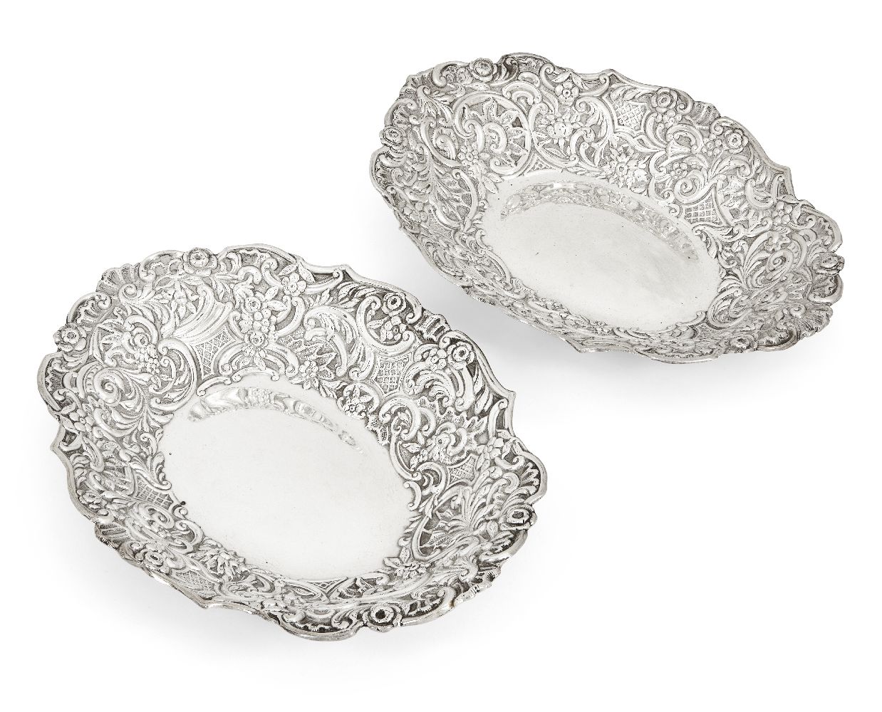 A pair of late Victorian repousse silver dishes, London, 1890, William Comyns & Sons, of shaped oval