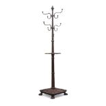 A Victorian revolving cast iron coat and stick stand, painted in faux oak, the square tray with