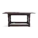 A 17th century and later oak refectory table, the plank top raised on turned legs and block feet,