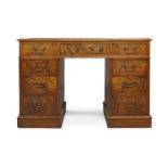 A late Victorian walnut pedestal desk, inset with leather skiver, three frieze and six pedestal