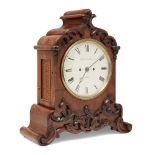 A Victorian walnut eight day mantel clock, late 19th century, the walnut case with relief carved
