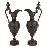 A pair of French bronze ewers, early 20th century, in the manner of Clodion, each with tapering