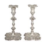 A pair of George II cast silver candlesticks, London, 1751, William Gould, the knopped stems to