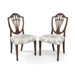 A pair of George III mahogany side chairs, circa 1780, the shield shape back rests with balloon