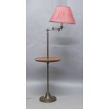 A brass and mahogany floor lamp, 20th century, the adjustable arm above mahogany tray, raised on