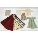 A selection of dolls clothes, together with lace, trimmings and an assortment of material for a doll