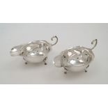 A pair of silver sauce boats, Birmingham, 1938, Grant & Son, with scroll handles on three shell