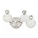 Four putti-decorated silver mounted glass vanity vessels comprising: three globular glass bottles