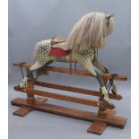A hand painted carved wooden rocking horse, 20th century, with glass eyes, real horse hair,