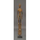 An African tribal carved softwood figural mask, card softwood, comprising a female figure standing