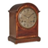 A German mahogany mantel clock, circa 1920, the case with arched moulded cornice, the brass dial