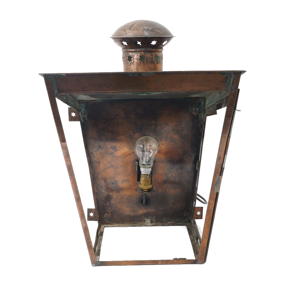 An English copper wall lantern, early 20th century, of tapering from, the pierced chimney with