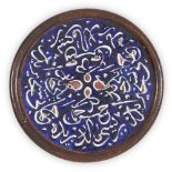 A circular pottery inscription tile, Iran, early 20th century, blue ground in wood frame, restored