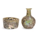 Two iridescent Roman glass vessels Circa 4th Century A.D. and Later, a globular glass bottle with